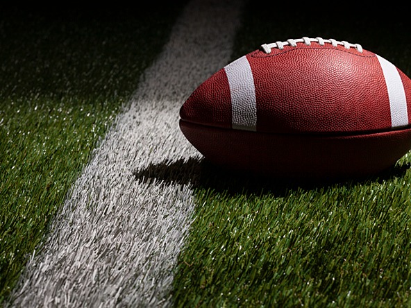 Ball used in American football lying on the pitch